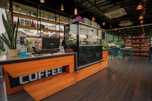 Mostrador de cafetería con detalles de madera y una vitrina de vidrio.