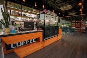 Mostrador de cafetería con detalles de madera y una vitrina de vidrio.