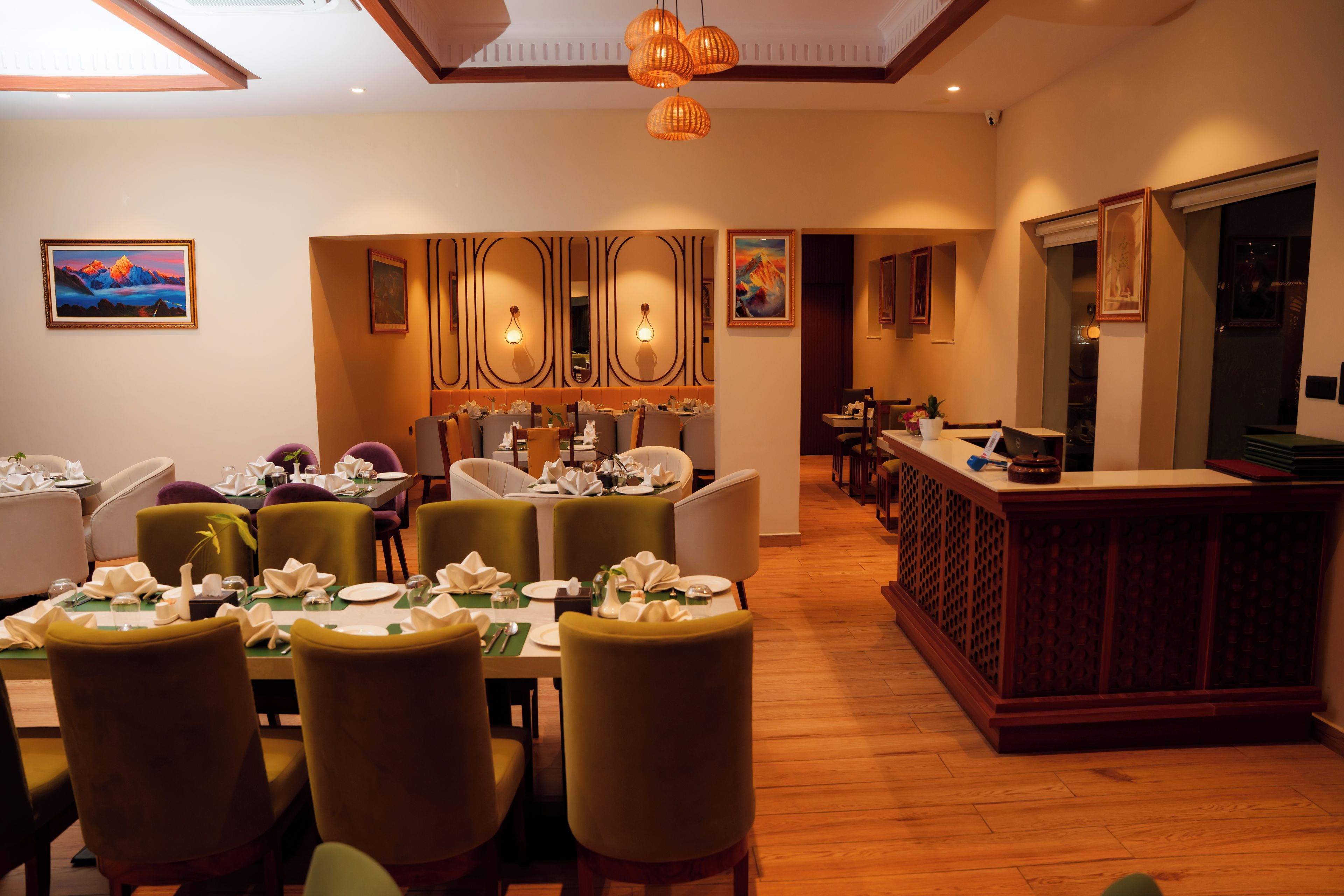 A restaurant with a long counter, multiple dining tables, and chairs.
