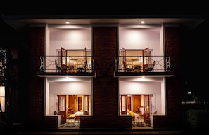 A two-story building with balconies, a dining area, and a bedroom visible through the windows. - Dreamland Gold Resort (Tilottama)
