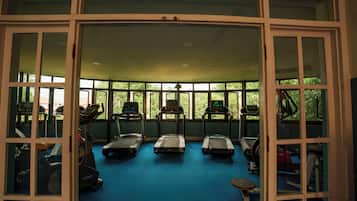 A gym with treadmills, stationary bikes, and exercise equipment.