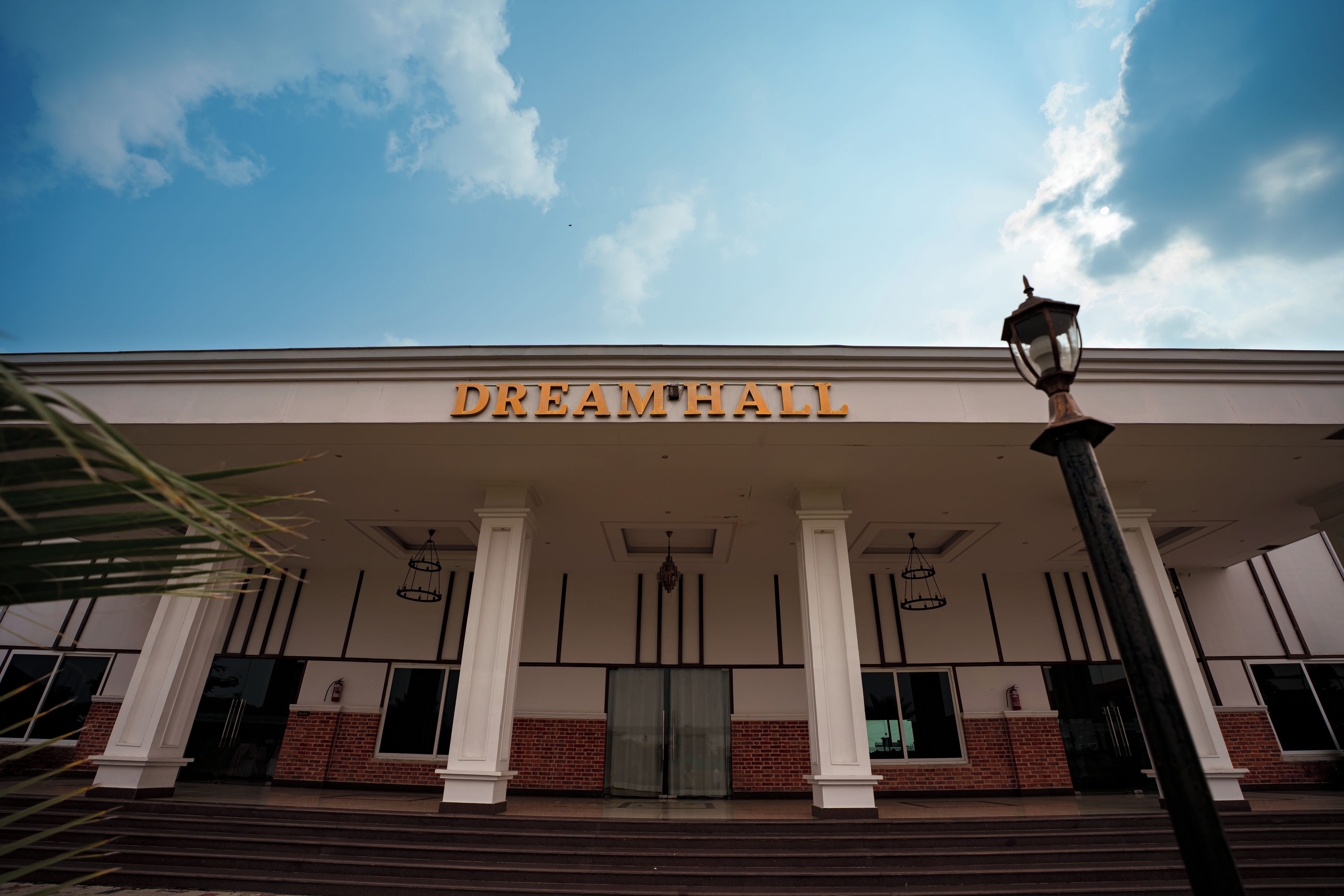 A building with a sign reading 'DREAMWALL' and a street lamp in front.