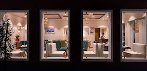 A hotel lobby with seating areas, a reception desk, and artwork on the walls. - Dreamland Gold Resort (Tilottama)