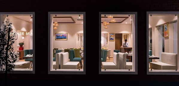 A hotel lobby with seating areas, a reception desk, and artwork on the walls. - Dreamland Gold Resort (Tilottama)