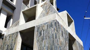 Un edificio de varios pisos con una fachada de piedra distintiva y balcones.