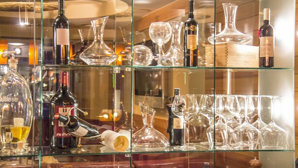 Une exposition de bouteilles de vin et de verres à vin sur des étagères.