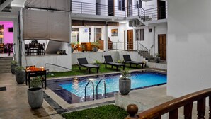 A pool area with lounge chairs, a small pool, and a staircase leading to an upper level. - Sea Breeze (Mirissa)