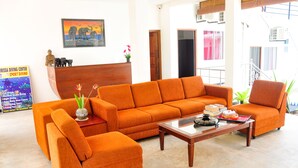 A bright living room with orange sofas, a wooden coffee table, and a framed picture on the wall. - Sea Breeze (Mirissa)