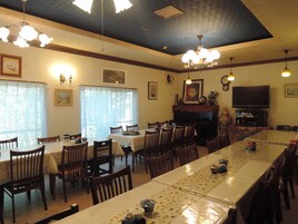 Comedor con varias mesas, sillas, un piano y un televisor.
