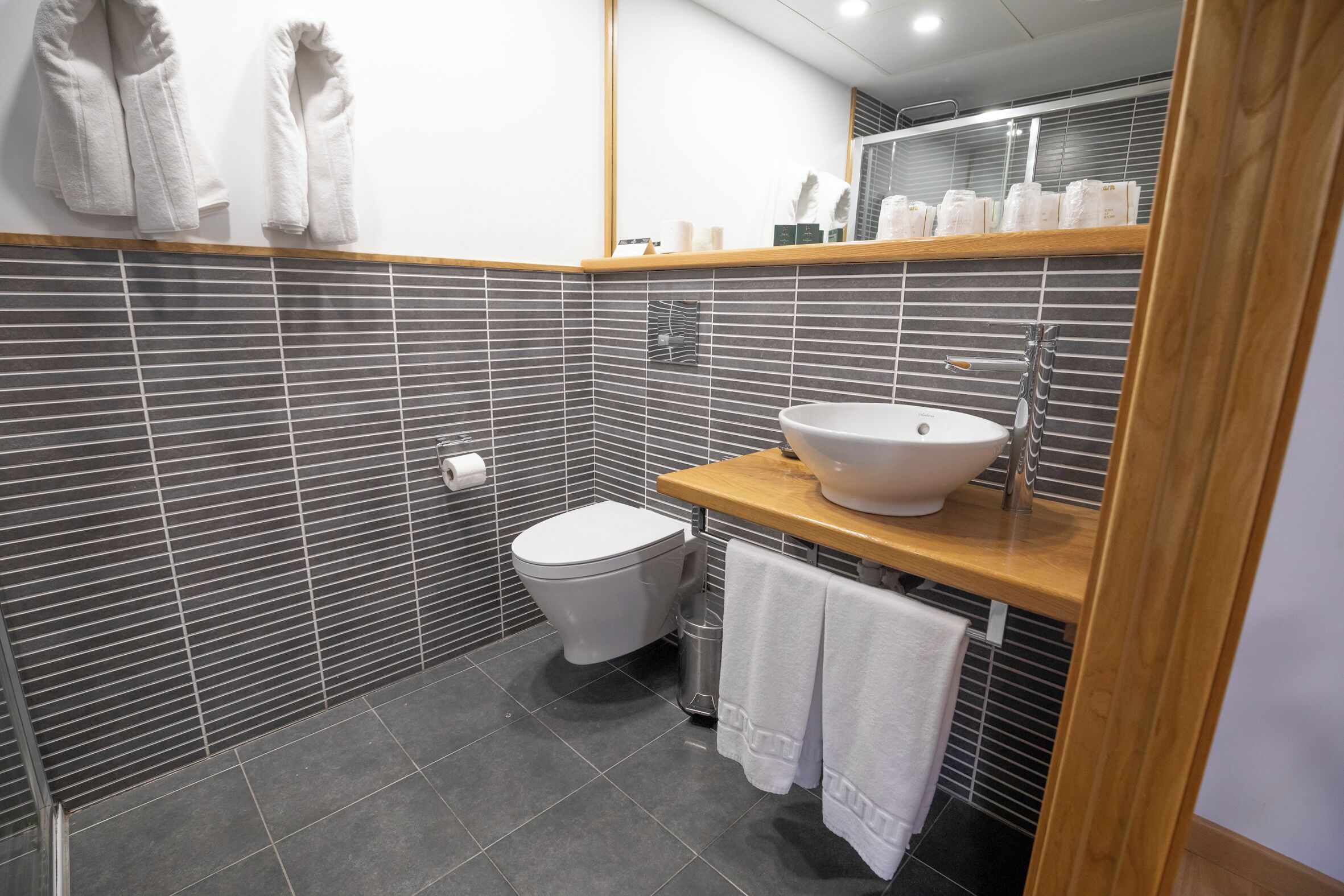 A modern bathroom with a toilet, sink, and towel rack.
