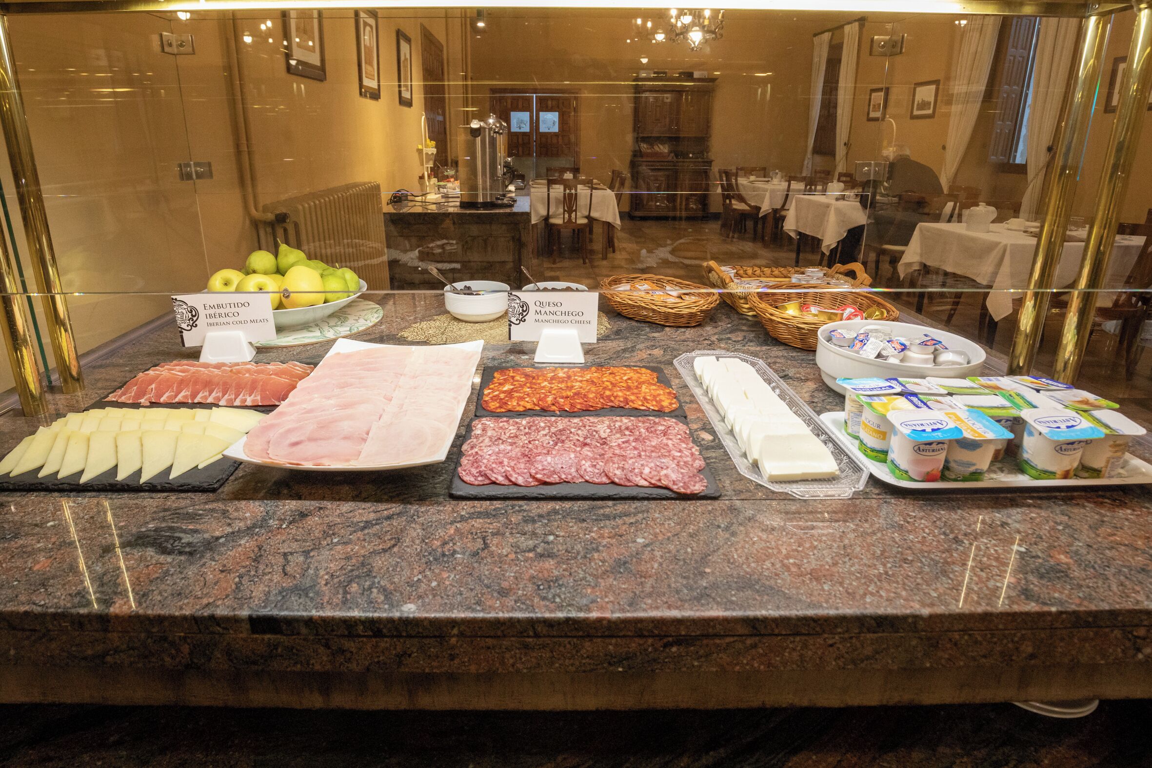 A buffet with various food items including meats, cheeses, and fruits.