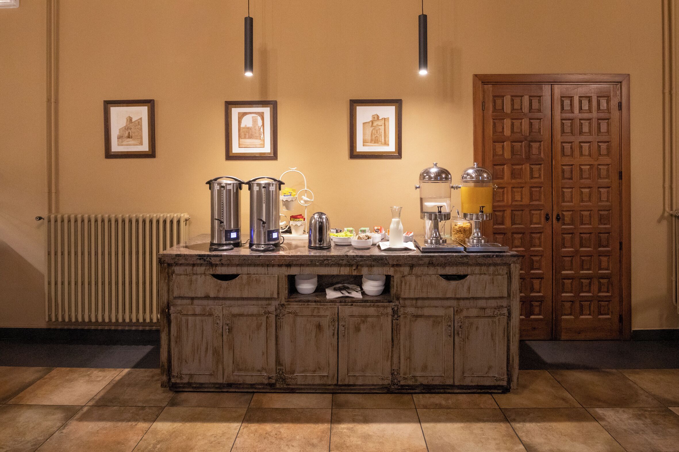 A kitchen area with a wooden island, equipped with various appliances and a coffee machine.
