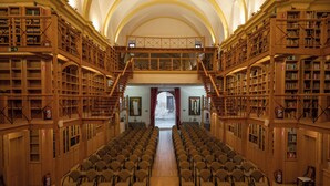 A spacious library with rows of chairs and bookshelves. - Hospedería del Seminario (Cuenca)