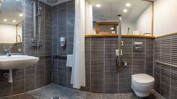 Un baño moderno con lavamanos, inodoro y ducha.