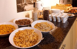 A breakfast buffet with various cereals, fruits, and pastries. - Apartement Silverpeak (Lauterbrunnen)
