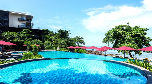 Alberca al aire libre, sombrillas en la alberca y camastros 