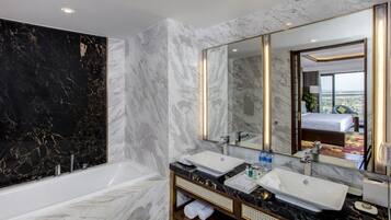 A modern bathroom with a large mirror, two sinks, and a bathtub.