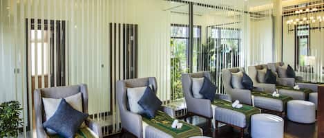 A spa area with multiple massage chairs, each with a towel and a green mat.