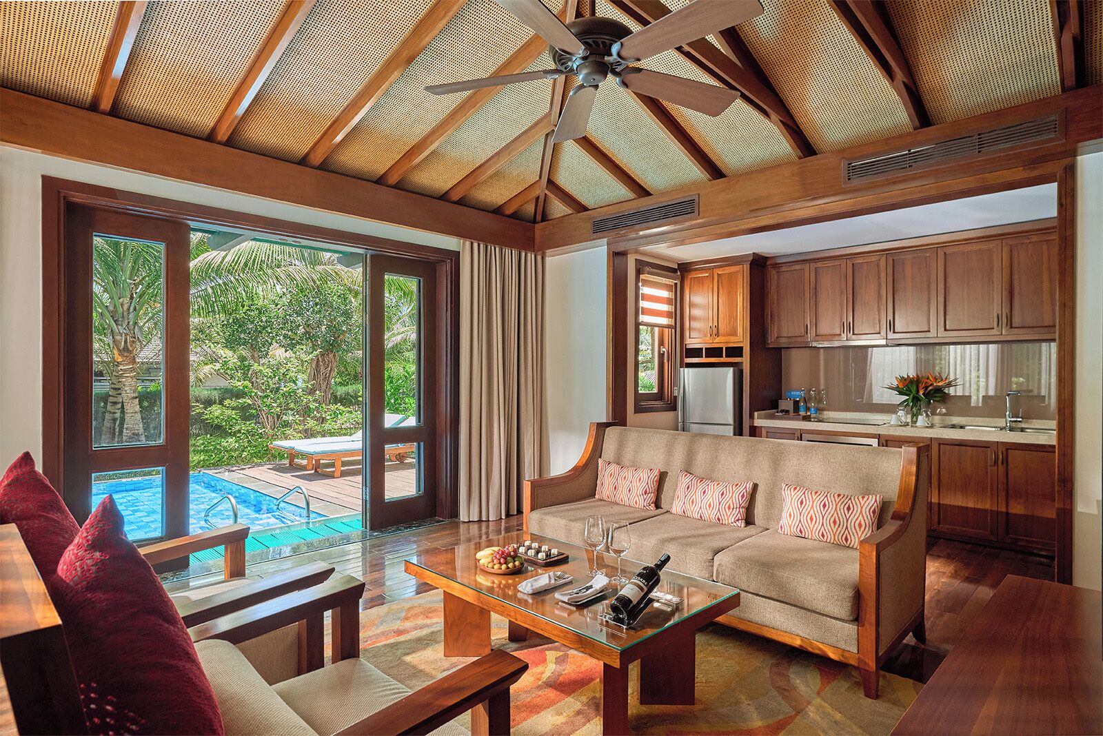 A spacious living area with a sofa, coffee table, and a view of a swimming pool.