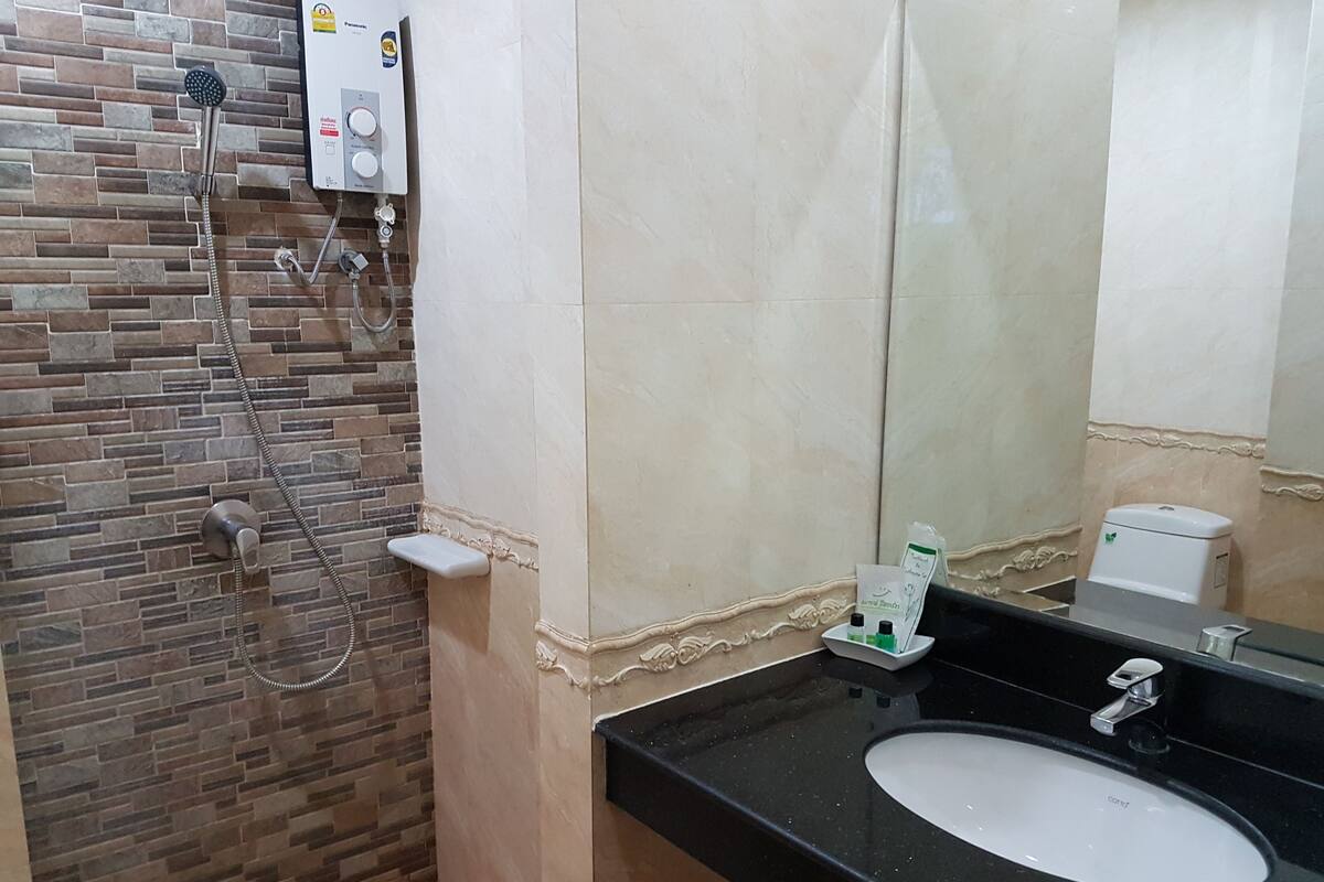 Ein Badezimmer mit Dusche, Waschbecken und Toilette.