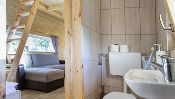 A modern bathroom with a toilet, sink, and wooden staircase.