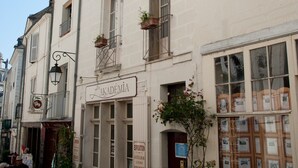 A building with a sign reading "L'AKADENIA" and a door labeled "EXPERTISSE." - La Demeure Saint-Ours (Loches)