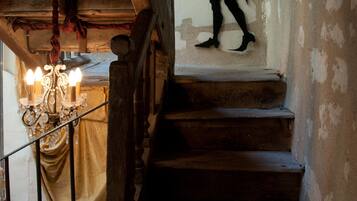 A staircase with a chandelier and a wall with a child's silhouette.