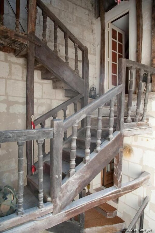 A wooden staircase with a rustic design, leading to an upper level.