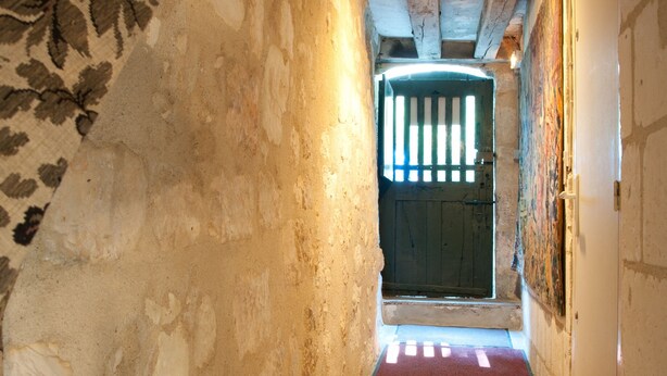 A narrow hallway with a wooden ceiling, a red carpet, and a door at the end. - La Demeure Saint-Ours (Loches)