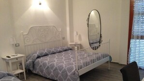 A bedroom with a single bed, a bedside table, a mirror, and a chair. - Residenza Cisanello (Pisa)