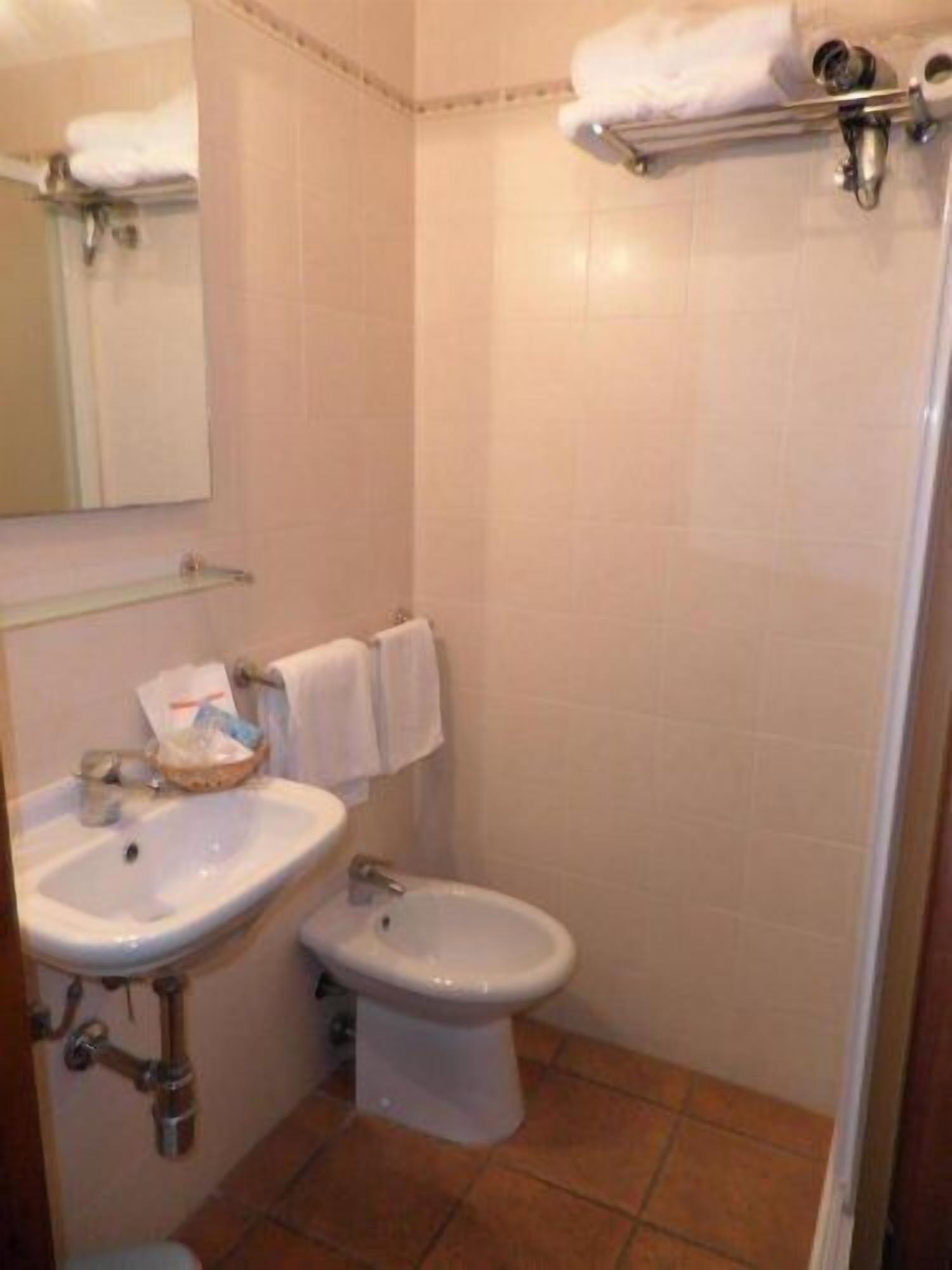 A bathroom with a sink, toilet, and shower area.
