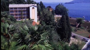 A hotel with multiple floors, a prominent tower, and a view of the sea. - Residence Tre Ponti (Verbania)