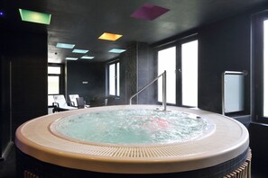 A hot tub in a modern room with large windows, a staircase, and a seating area. -  Carlsbad INN hotel & apartments (Dalovice)
