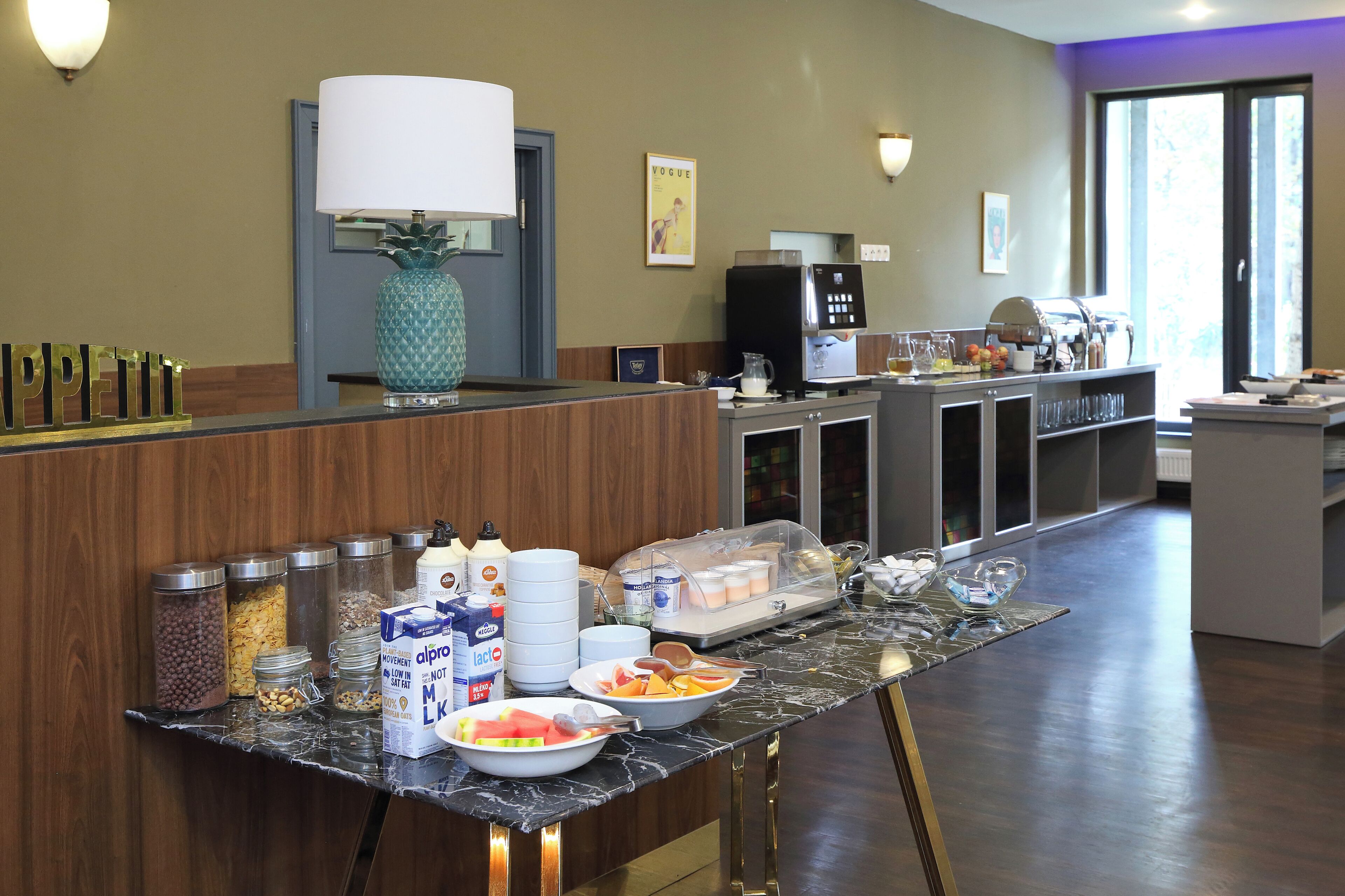 Un espace d’accueil d’hôtel avec un buffet proposant divers plats et boissons.