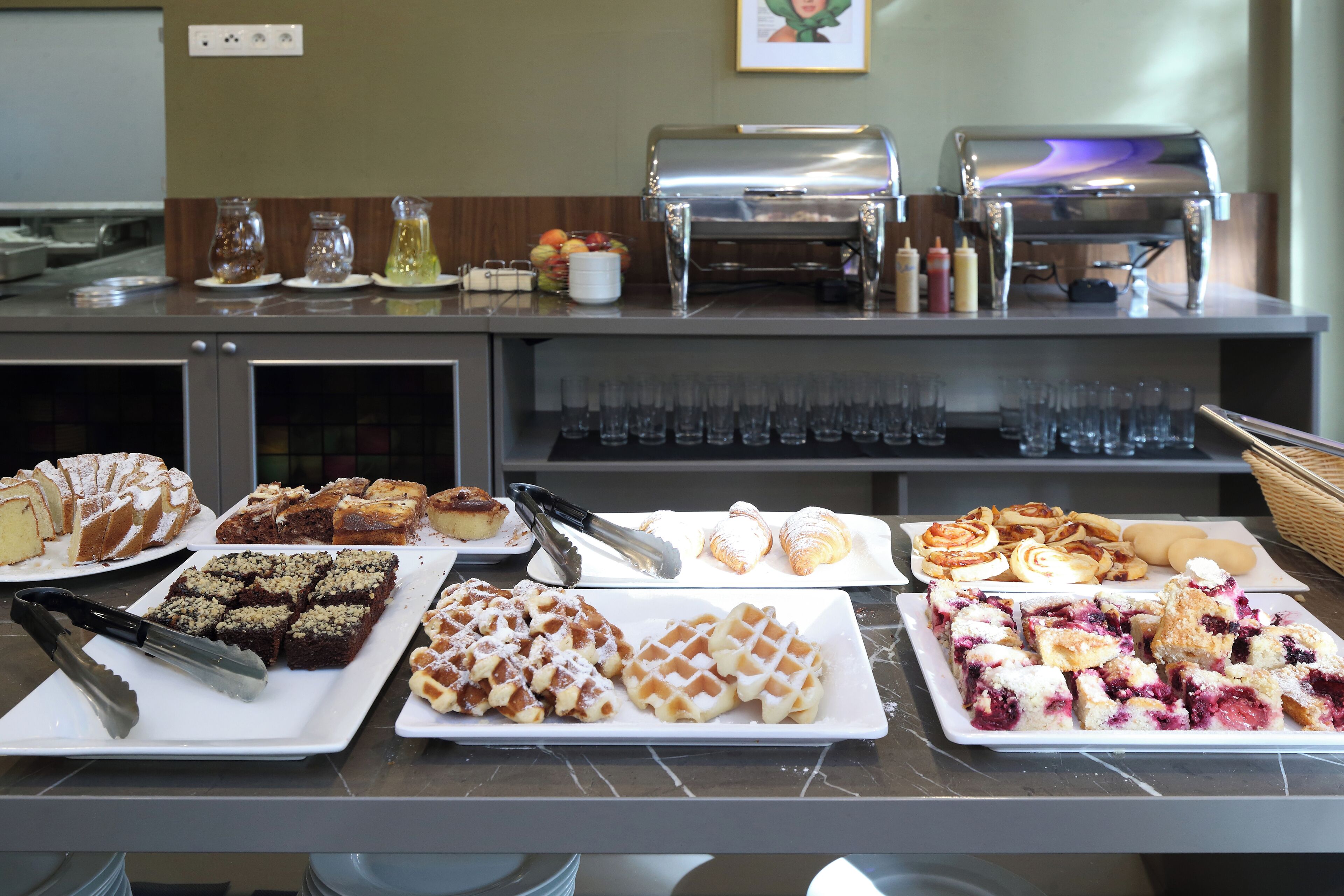 A buffet with various desserts and beverages.