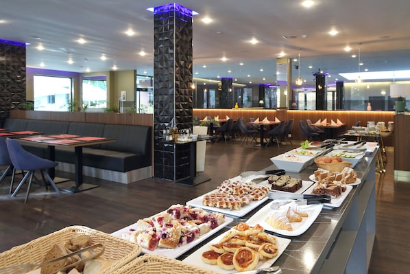 A buffet with various food items, seating arrangements, and a modern interior design.