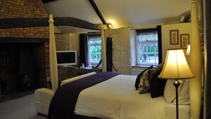 A bedroom with a fireplace, a bed, a TV, and a window with curtains. - Home Farm Bed & Breakfast (Milton Keynes)