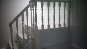 A staircase with white balusters and a handrail, leading to an upper floor.