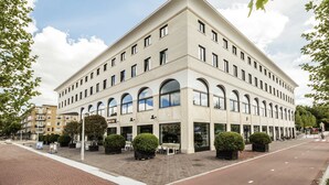 A modern building with a flat roof, large windows, and a brick-paved ground. - The July - Twenty Eight (Amsterdam)