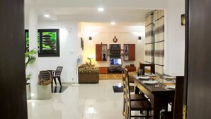 Amplia sala de estar con mesa de comedor, sillas, sofá y televisor.