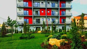 A multi-story building with balconies, surrounded by well-maintained gardens and trees. - Sangria Luxury Family (Navodari)