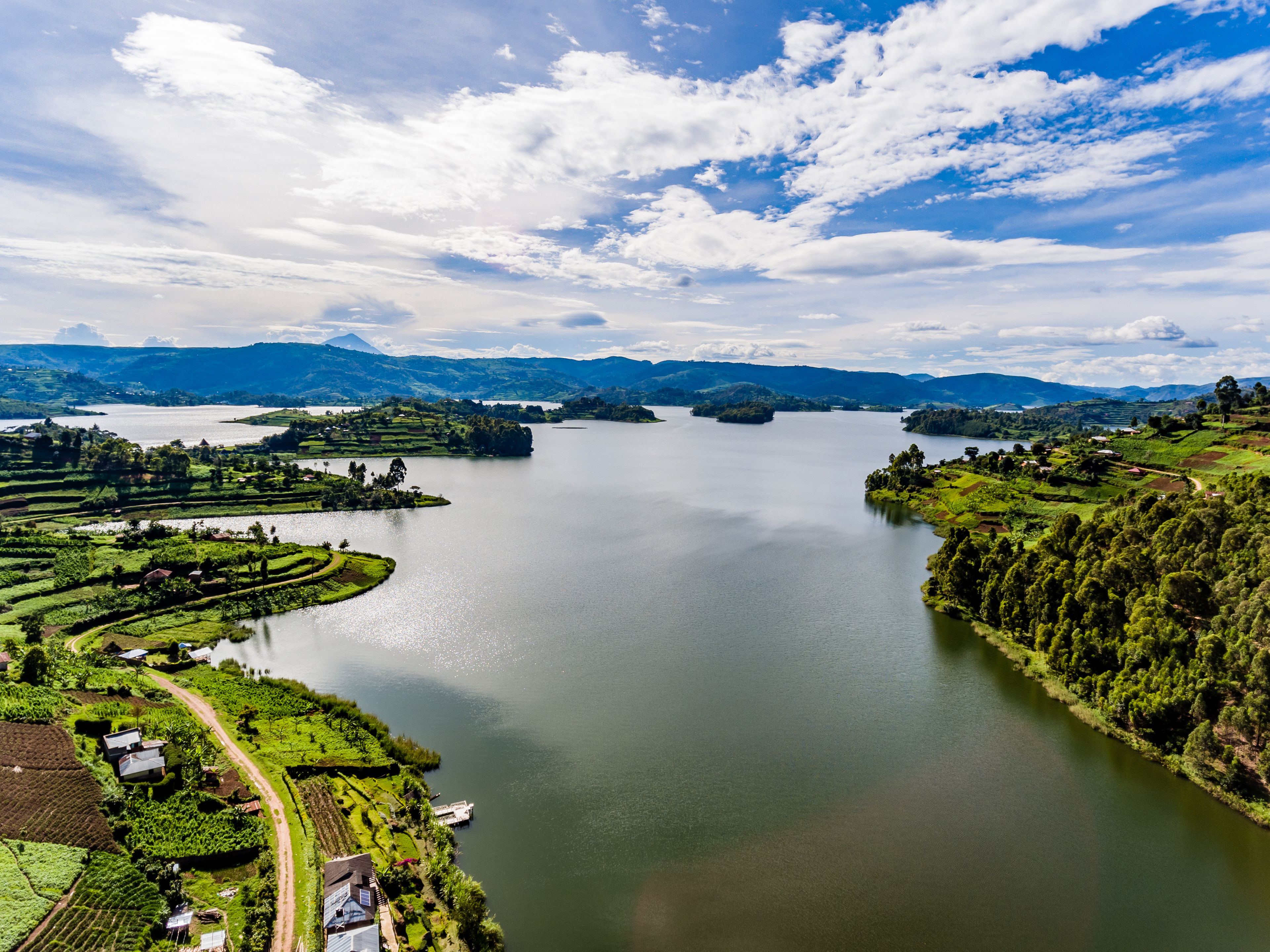 Vista panorámica de un lago rodeado de colinas cubiertas de vegetación y campos en terrazas.