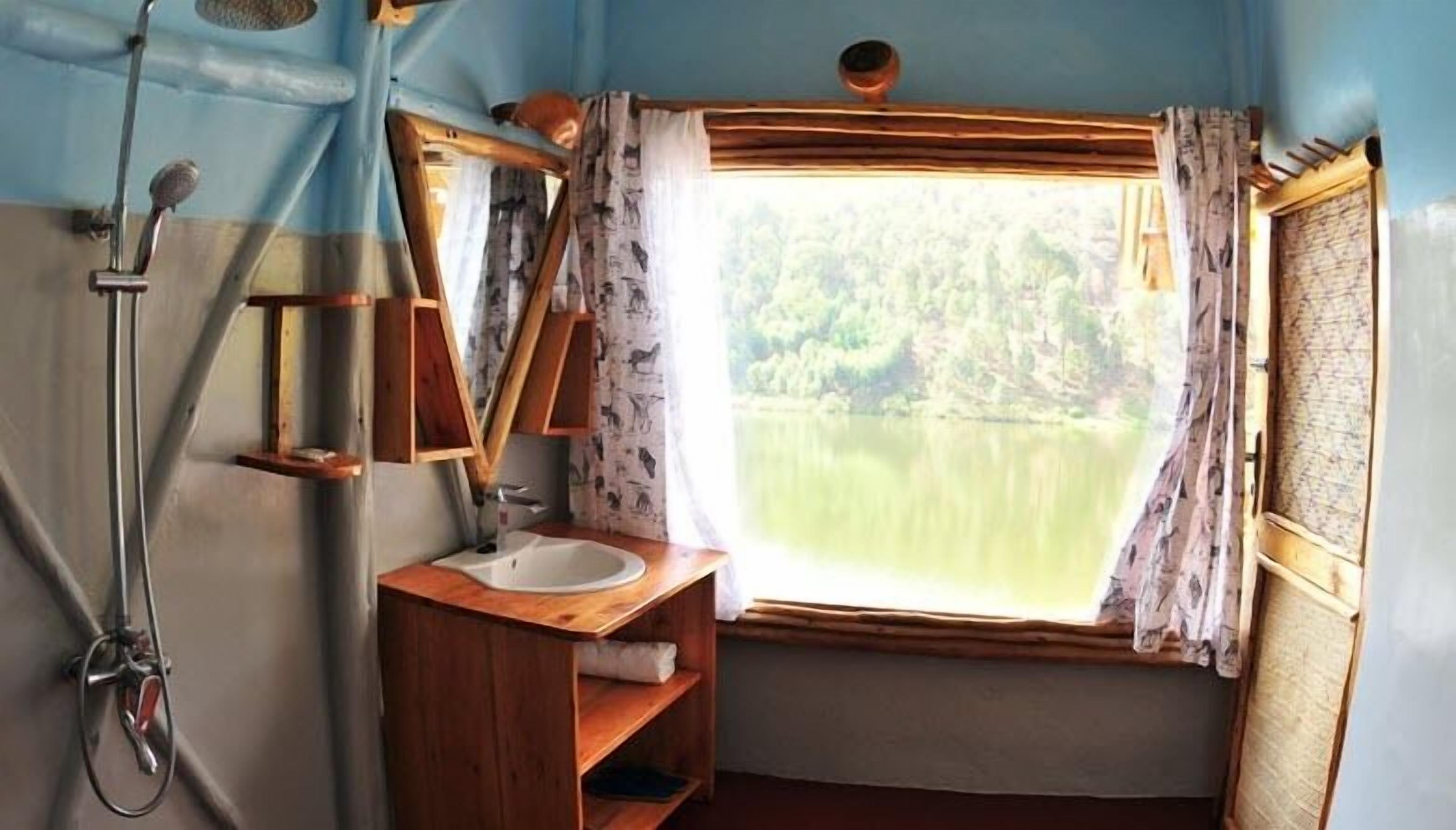 Een badkamer met een houten wastafelmeubel, een spiegel, een wastafel en een douche.