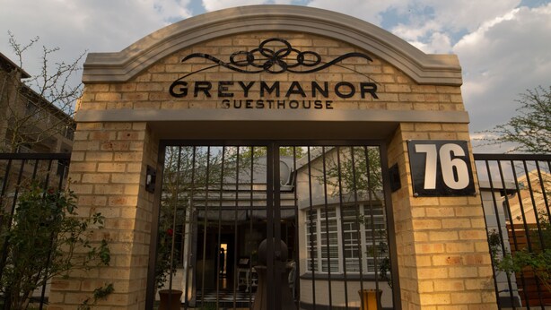 The entrance to Grey Manor Guesthouse, featuring a brick facade, a black gate, and the number 76. - Grey Manor Guesthouse (Potchefstroom)