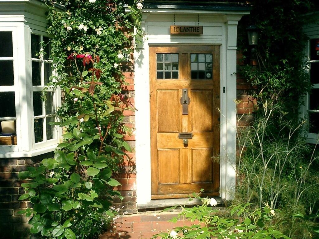 A wooden door with a nameplate reading "JOLANTHE" and a window to the left.