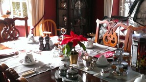 Une table à manger dressée avec différents plats, une plante en pot et un présentoir à menus.