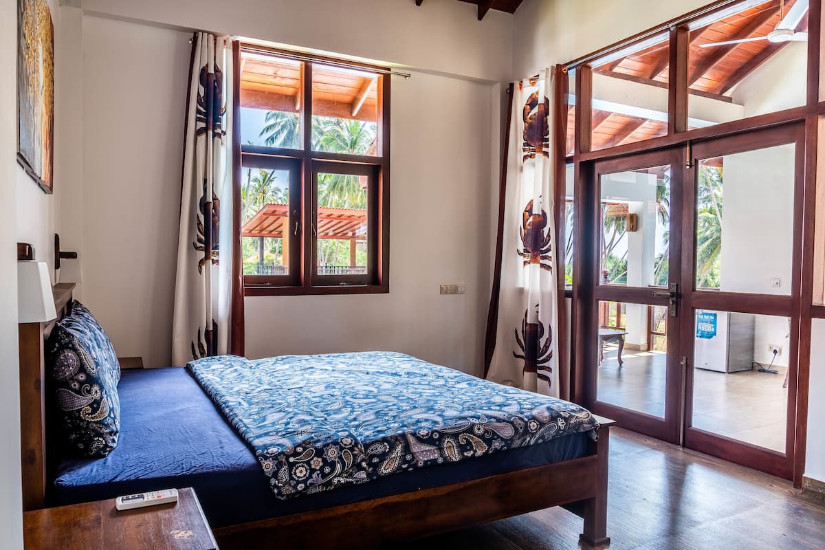 A room with a bed, a window, and a view of the outside.