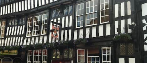 A traditional black and white half-timbered building with a sign for 'Crown Hotel, Brasserie & Bar'.