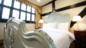 A bedroom with a large bed, two bedside lamps, and a window with curtains. - Crown Hotel (Nantwich)