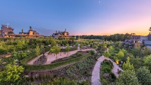 A residential area with modern buildings, a well-maintained garden, and a winding path. - Center Parcs Villages Nature Paris (Villeneuve-le-Comte)